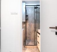 Bathroom with a glass shower enclosure and a sink in a 3-room apartment.