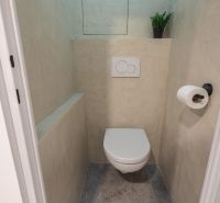 A toilet in a 3-room apartment with simple decoration and gray flooring.