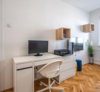 Workspace with a desk and chair in a 3-room apartment with a wooden decor floor.