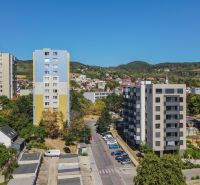 Apartment buildings and greenery on Sadmelijská Street in Bratislava - Rača, clear blue sky.