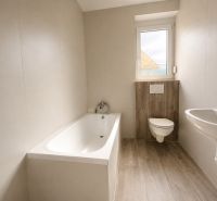 Bathroom with a bathtub, toilet, and sink, floor with wooden decor, family house.