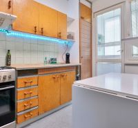 A kitchen in a 2-room apartment with a white countertop, cabinets, and a gas stove.