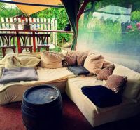 In Piešťany, there is a comfortable seating area with cushions and a wooden table by the family house.