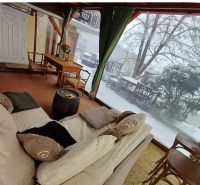Winter garden with a sofa, table, and chairs in a family house.