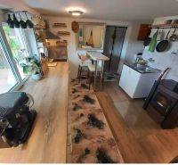 A kitchen in a family house with a wooden decor floor, view of the stove and dishes.