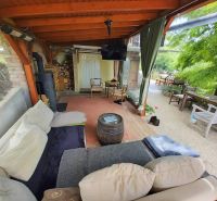 Covered terrace of a family house in Piešťany with comfortable seating and a stove.