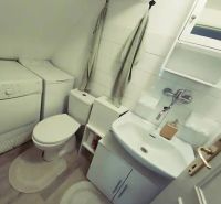 Bathroom in a family house with appliances, toilet, and sink.