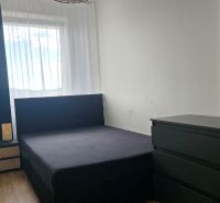 A bedroom with a bed and furniture in a 3-room apartment, floor with a wooden decor.