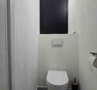 A stylish toilet with geometric tiles in a 3-room apartment, minimalist design.