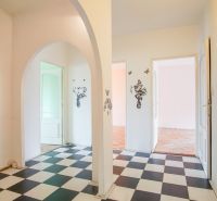 An interior with checkerboard tiles, an arch, and a floor with a wooden decor in a 3-room apartment.
