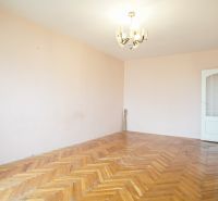 Interior of a 3-room apartment with a wooden decor floor and a chandelier on the ceiling.