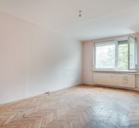 A room in a 3-room apartment with a wooden decor floor and white walls.