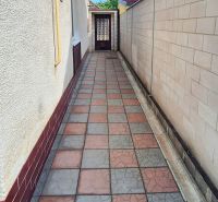 A narrow passage with paving next to a family house on Bodona Street in Piešťany.