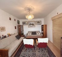 Living room in a 3-room apartment with carpets and bookshelves.