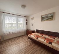 A room with a bed, paintings, and a floor with a wooden decor in a 3-room apartment.