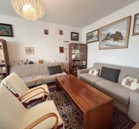 Living room in a 3-room apartment with sofas, armchairs, and paintings on the walls.