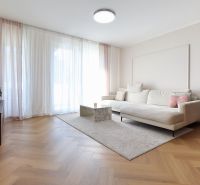 Living room in a 3-room apartment with a white sofa and a wooden decor floor.