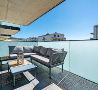 The balcony of a 3-room apartment on Dlhé lúky in Púchov with comfortable seating and a table.