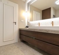 A bathroom with a large mirror and a hanging cabinet with a wooden decor in a 3-room apartment.