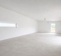 Empty room in a family house with white walls and large windows.