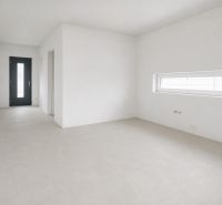 Empty room in a Family House with white walls and a rectangular window.