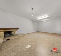 A spacious room with a fireplace and tiles in a family house.
