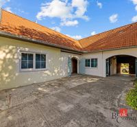 A family house in Budmerice with a sloped roof and a paved courtyard.
