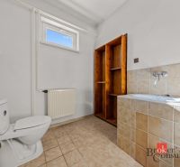 Bathroom in a family house with a toilet, bathtub, and ceramic tiles.