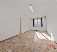 A bright room in a family house with a window and a wooden-patterned floor.