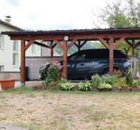 Carport at a family house in Medzibrod with floral decorations in the garden.