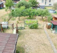 A garden at a family house in Medzibrod with a lawn, garden sheds, and tree planting.
