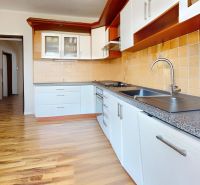 A kitchen in a family house with a wooden decor floor and cabinets.