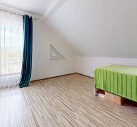 Attic room in a family house with a wooden decor floor and a view.