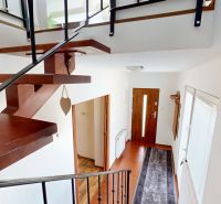 Wooden stairs, white wall, and floor with wooden decor in a family house.