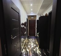 A hallway with a shiny floor and built-in lighting in a 4-room apartment.