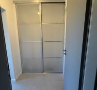 Sliding doors for a built-in wardrobe in a studio apartment.