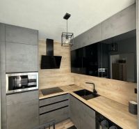 Kitchen unit with a microwave and a sink, floor with wooden decor, 1-room apartment.