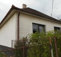 A family house in Trenčín with a fence and a garden, windows with brown frames.