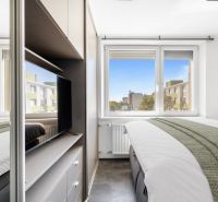 Bedroom with a bed, television, and a view from the window, 2-room apartment.