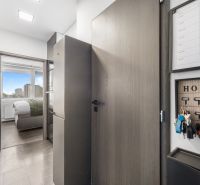 A kitchen in a 2-room apartment with a view of the bedroom, floor with a wooden decor.