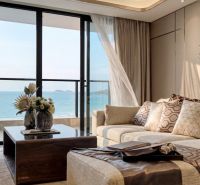 Living room in a 3-room apartment with a view of the sea and a wooden decor floor.