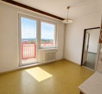 A white kitchen interior with a large window and yellow floor in a 3-room apartment.