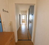 A hallway in a 3-room apartment with a wall-mounted telephone and laminate flooring.