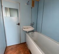 Bathroom with a bathtub in a 3-room apartment, blue walls and tiles with a pattern.