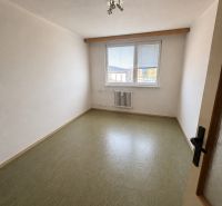 An empty room in a 3-room apartment with a window and a wooden decor floor.