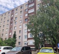 The apartment building on Železničiarska Street in Galanta shows a parking lot and greenery.