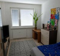 A room in a 2-room apartment with a desk and decorative ribbons on the wall.