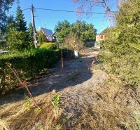 A plot for residential purposes in Vojka nad Dunajom, surrounded by greenery and shrubs.