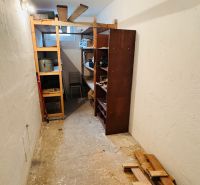 Storage space in a 3-room apartment with shelving units and building materials.