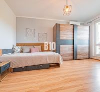 A one-room apartment with a bed, a wardrobe, and a floor with a wooden decor.